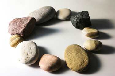 A white counter with a circle of unique rocks sitting on it.